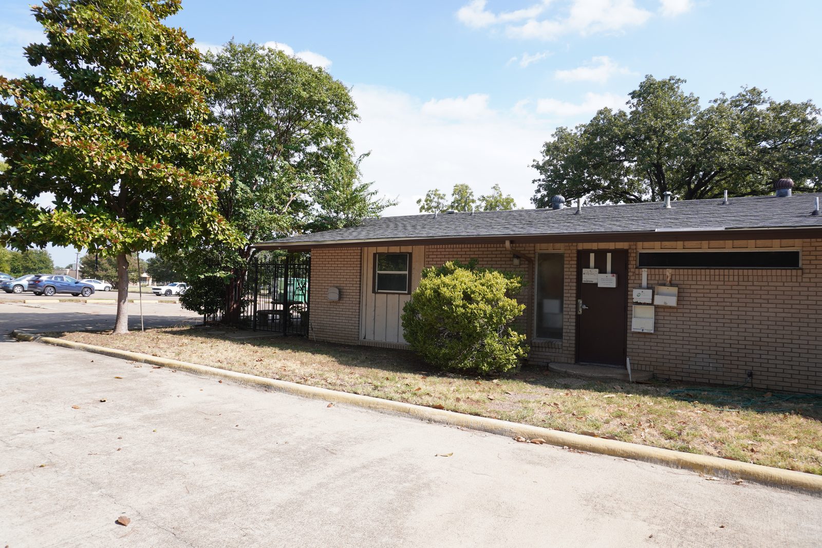 Brick side elevation with the separate staff entrance, beside the fenced patio.