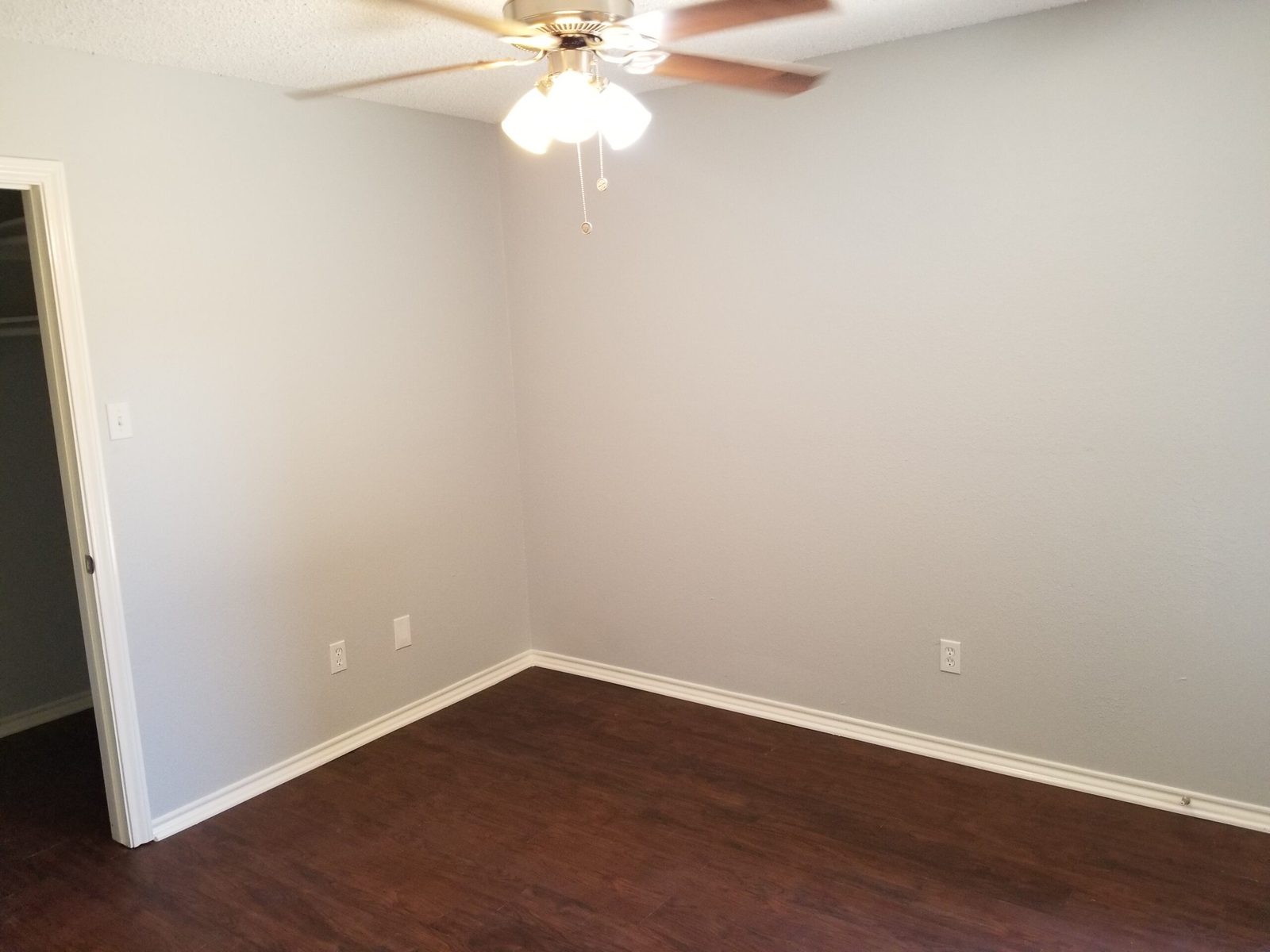 Bedroom one with ceiling fan and wood-look flooring
