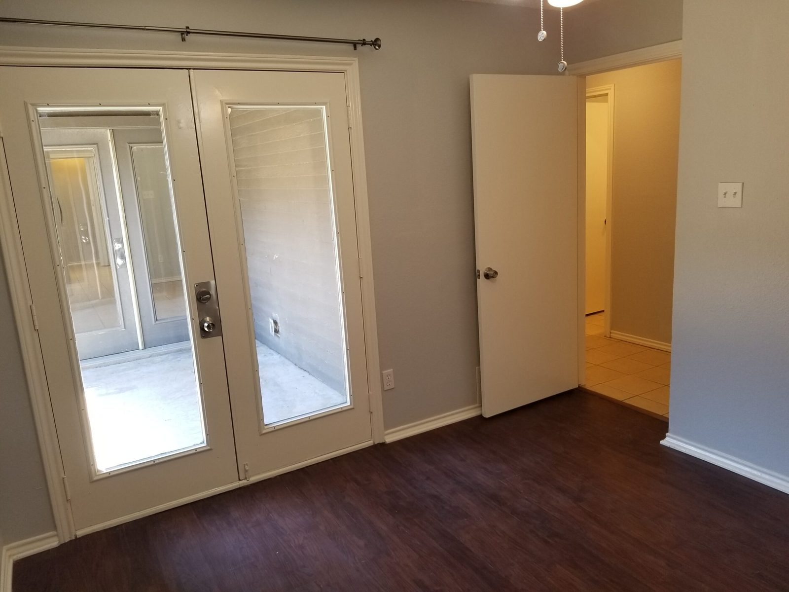 Bedroom one with mirrored French doors opening toward the patio