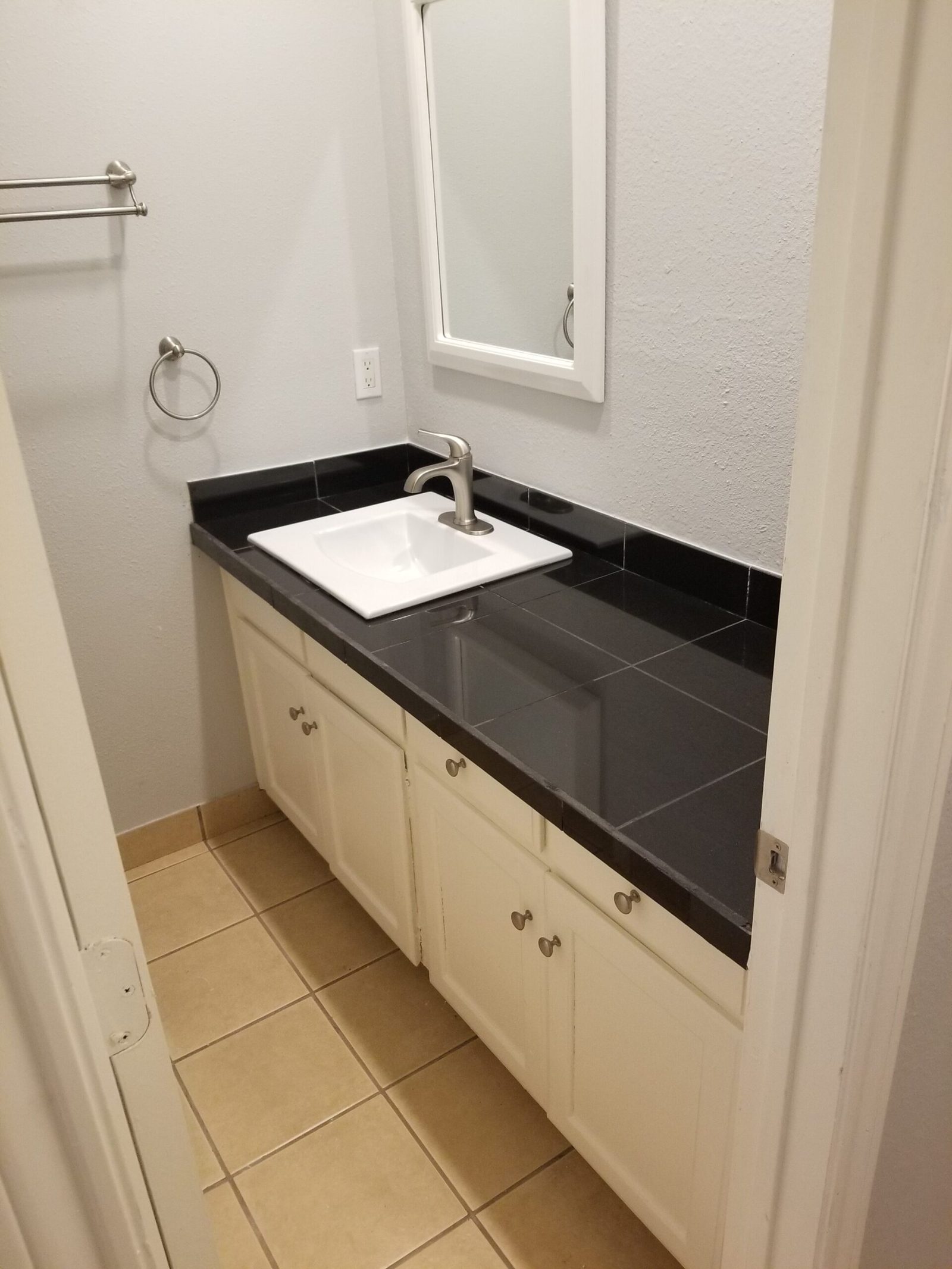 Vanity and dressing area with stone-look counter and framed mirror