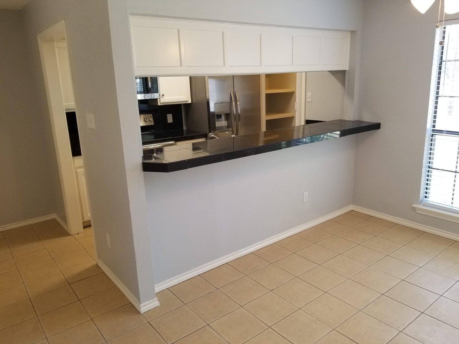 Open kitchen with pass-through breakfast bar looking into the living area